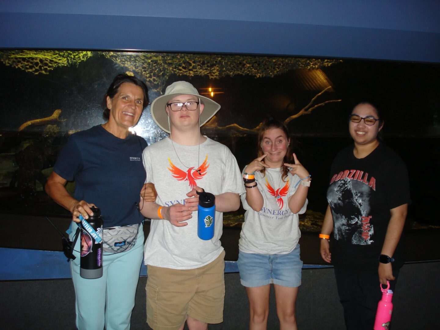 Group of friends posing at an aquarium.